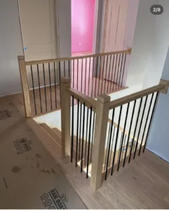Upstairs view of a second wooden staircase featuring stylish railings.