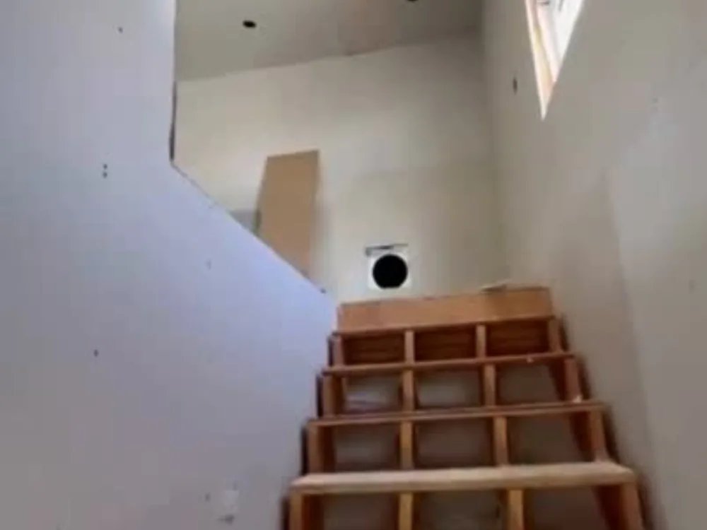 Drywall completion in Bridgeport showing finished wall surfaces around a staircase under construction.