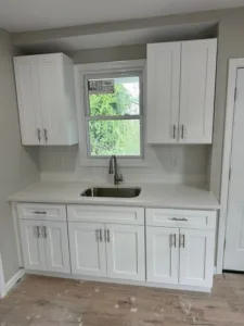 White shaker kitchen cabinets with sink area, showcasing sleek design and practical layout.